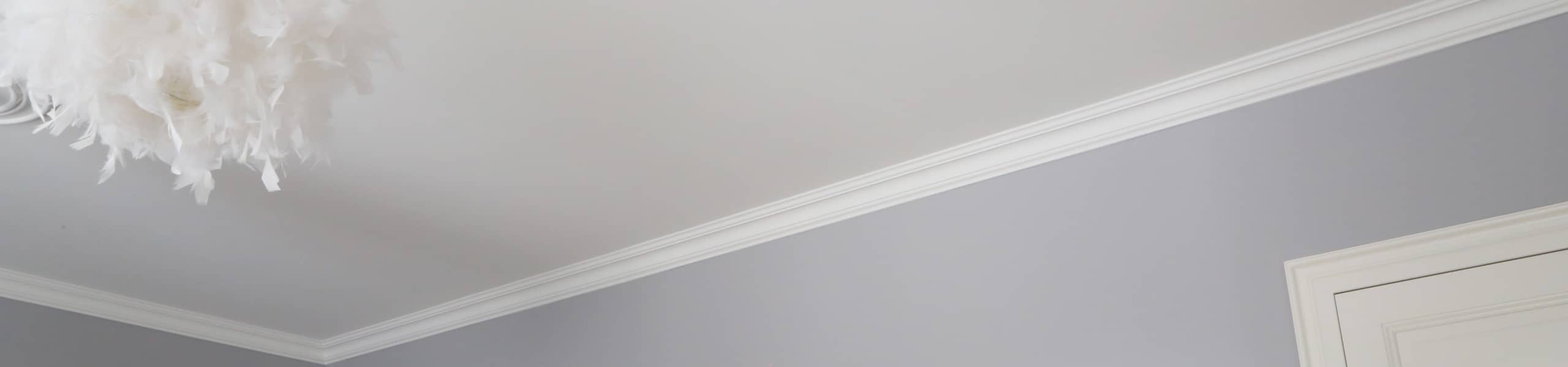 Peinture et finition chambre à coucher teintes pastelles : blanc et violet. Lustre blanc en plumes, miroir et porte intérieure.